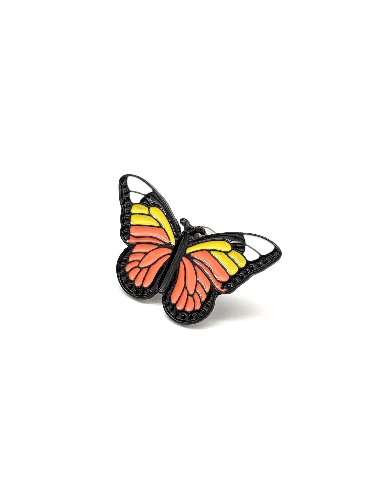 A decorative butterfly-shaped hat pin with orange, yellow, and black colors on a white background.