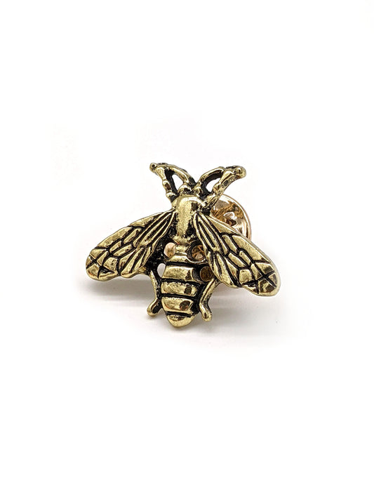 A golden bee-shaped pin designed for attachment to hats.