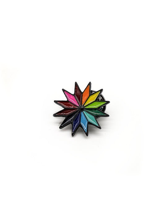 A colorful pinwheel-shaped brooch designed to be attached to a hat.
